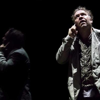 Brendan Cowell (John) talks on the phone and is reflected in the glass in Yerma at the Young Vic, photo by Johan Persson