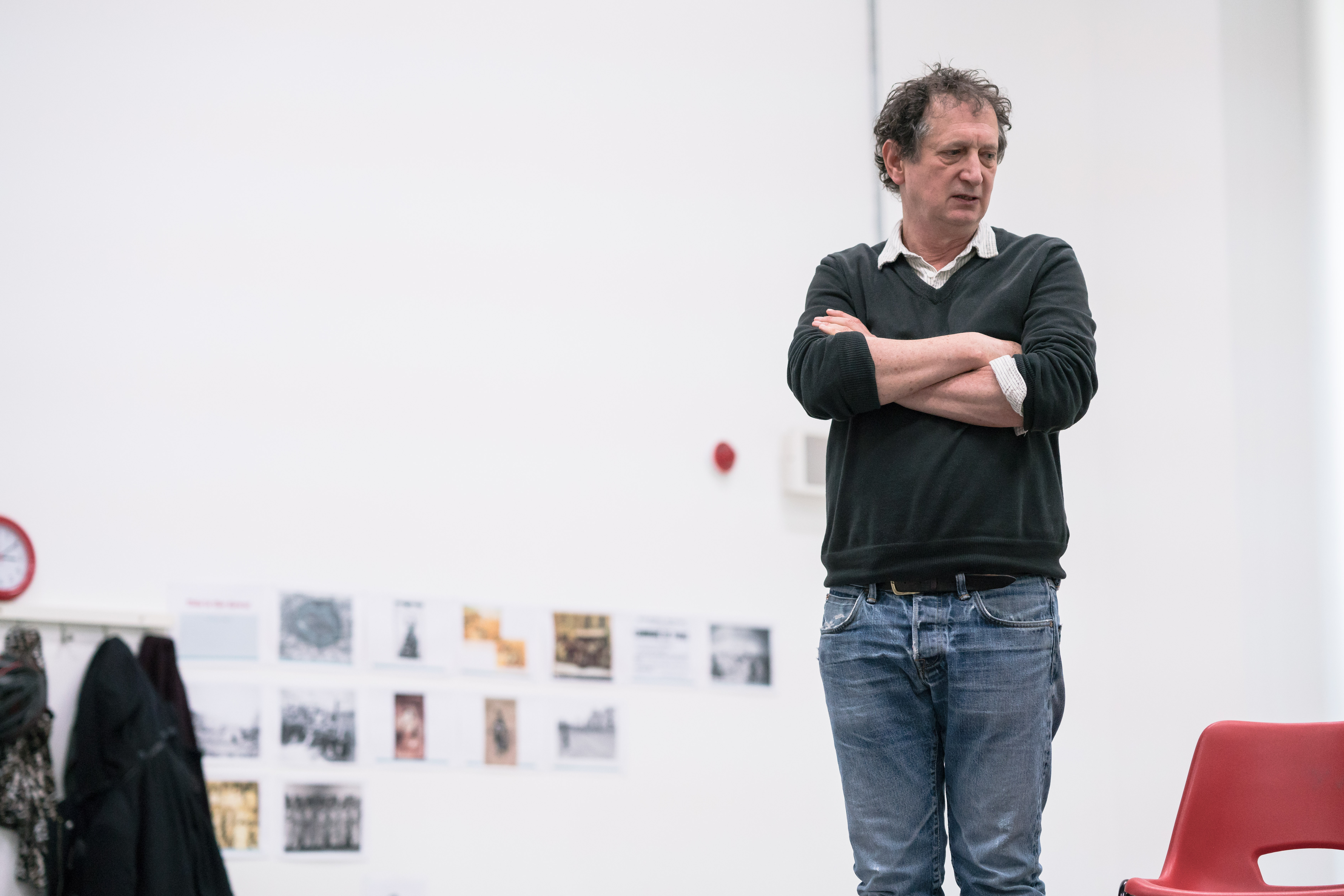 David Lan stands arm crossed, face deep in concentration in rehearsals for Why It's All Kicking Off
