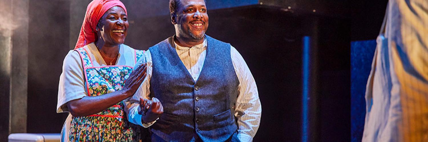 Sharon D. Clarke as Linda Loman and Wendell Pierce as Willy Loman stand together smiling and holding hands. 