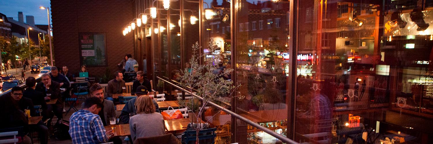 The Cut Bar's terrace in the evening with people seated and drinking