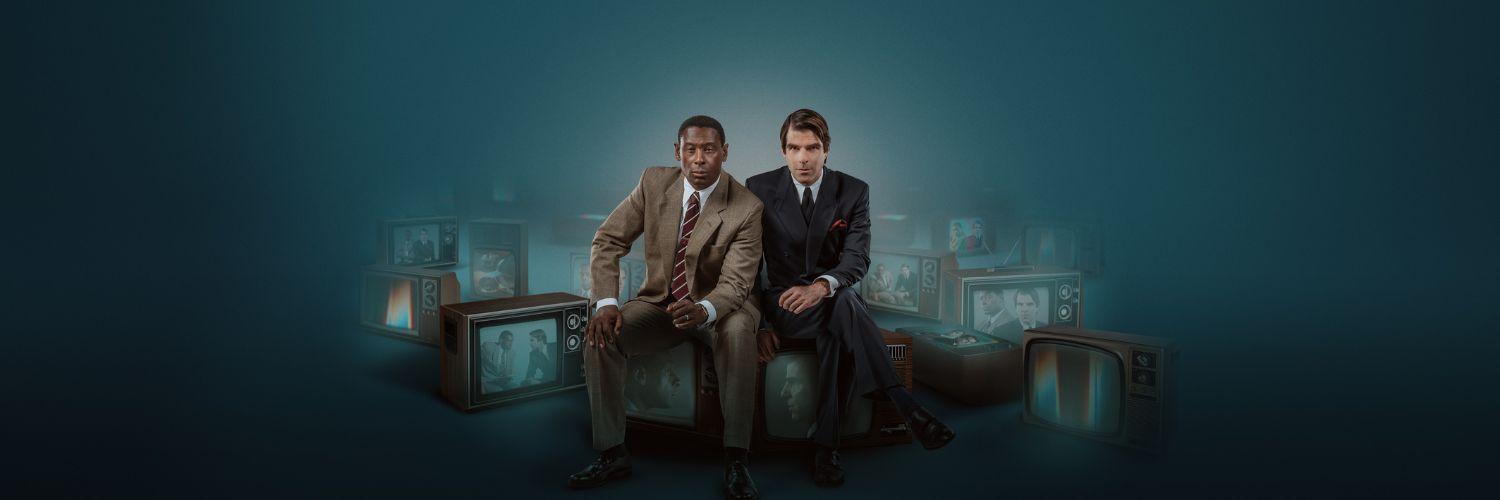 Best of Enemies West End. From 14th November 2022 to 18th February 2023. Image description: Two men in suits, sat side by side, on a number of TVs with their faces on the screen. The words "Best of Enemies' are in white in the center right of the image. 