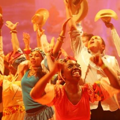 A group of people cheering whilst holding cowboy hats aloft