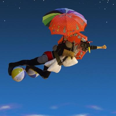 An image of a man in an eccentric costume wearing goggles and holding multiple parasols flying through a blue background in a superman pose with one arm extended