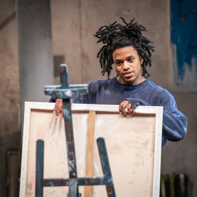  Jeremy Pope in The Collaboration (c) Marc Brenner. Basquiat placing a large canvas on an easel 