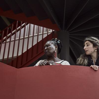 Two people leaning over the edge of a red staircase