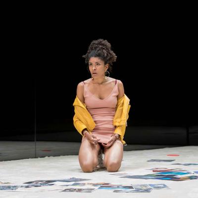 Thalissa Teixeira (Des) kneels in a yellow cardigan in Yerma at the Young Vic. Photo by Johan Persson