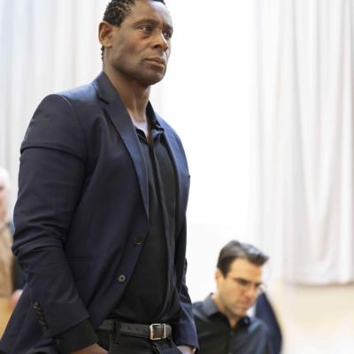 Actor David Harewood stands with hands in his pockets looking forward. 