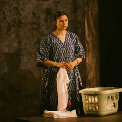 Zainab Hasan standing folding laundry. Isha Shah.