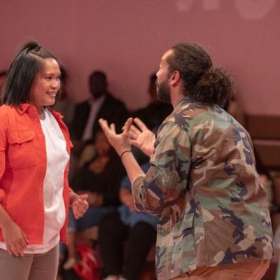 Man hands open gesturing to woman. The American Dream 2.0 Photo by Anthony Lee