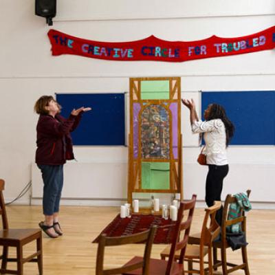 two people inside surrounded by chairs and props