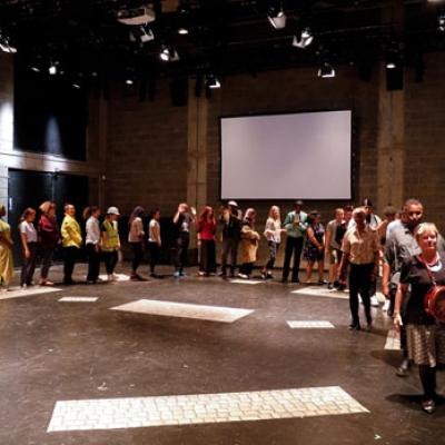 A large group of people in an auditorium in a semi circle formation