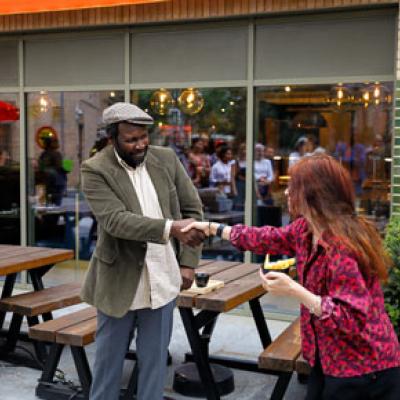 Two people outside shaking hands