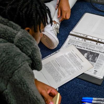 Two people looking through a file of documents from the Young Vic archive