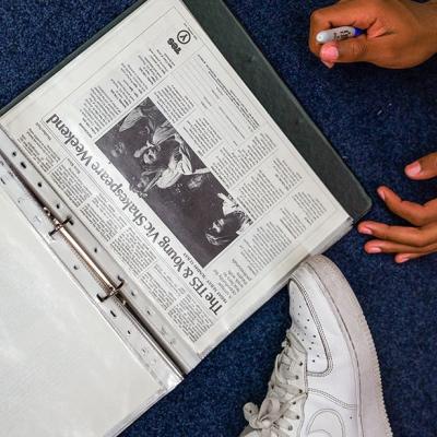 An old newspaper clipping in a file of documents, with a black and white photograph of some people below a headline reading: 'The TES and Young Vic Shakespeare weekend'