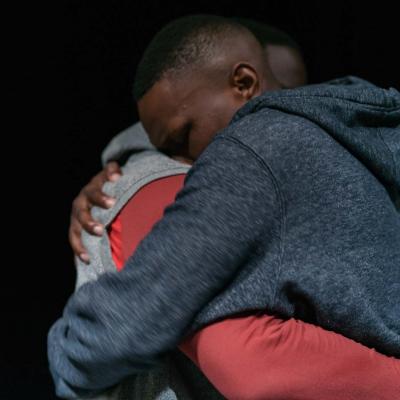 Two male performers embrace © Leon Puplett