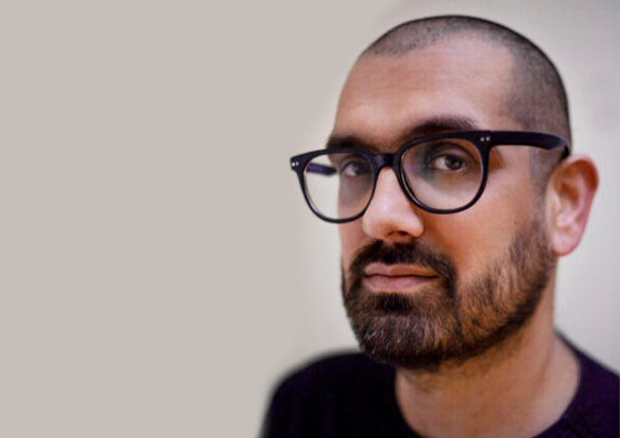 Image of Darren Chetty. He is wearing a black tshirt, black glasses and has a beard.