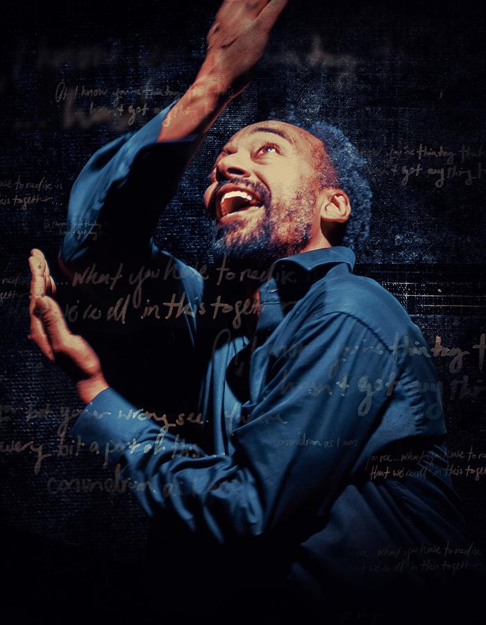 Black man, wearing a blue shirt, looking up and raising his arms to the sky. He’s surrounded by gold handwriting and a dark, textured background.