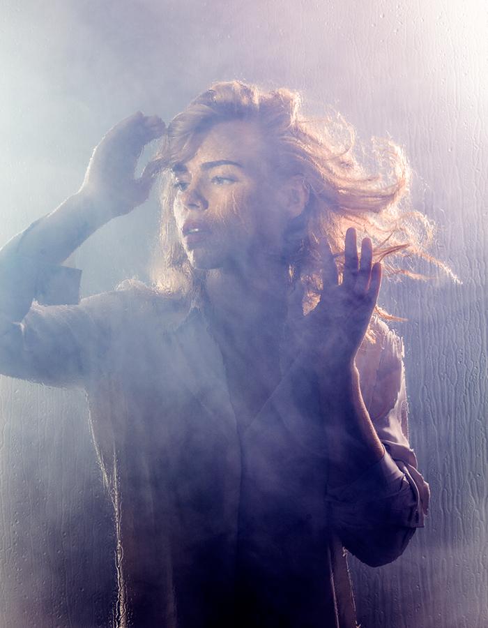 Women looking distressed with wind blowing through her hair 