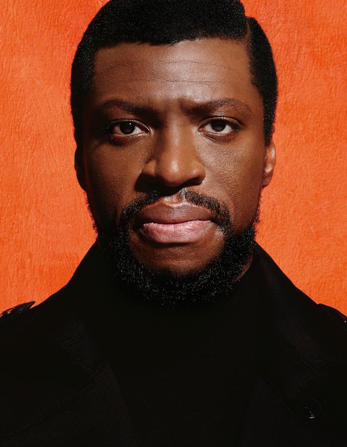 Mandela. From 29th Nov to 4th Feb. Image description: Michael Luwoye, wearing a dark coat, staring intently at the camera against an orange background