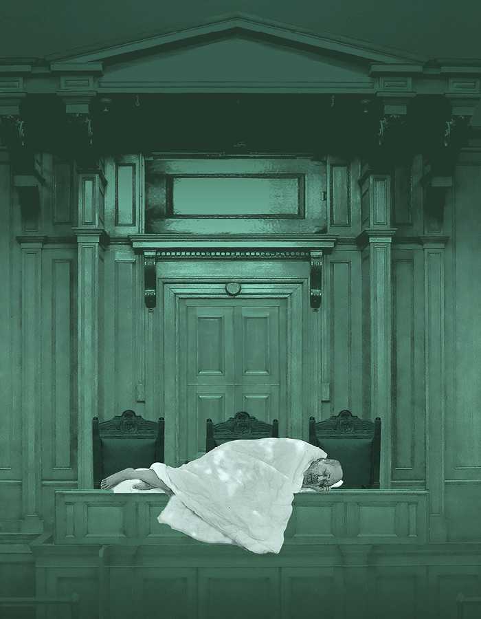 Against a teal background, an elderly man lies on a table in the House of Commons wrapped in a white blanket.