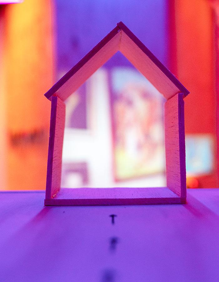 close up of wooden house with bright purple and yellow set. Photography by Anthony Lee