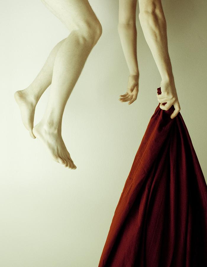 A red shawl being held from the hand a suspended being