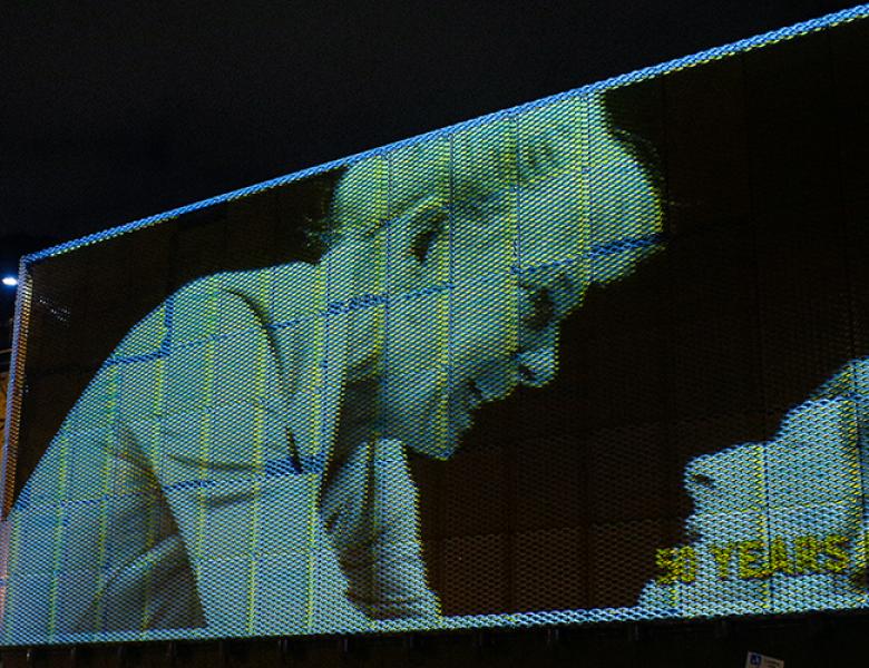 A black and white photo of Vanessa Redgrave in the 1985 Young Vic production of Ghosts is projected outside the the Young Vic  building