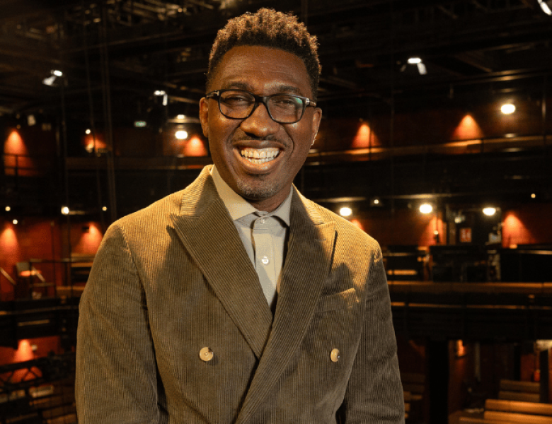 Kwame Kwei-Armah in a green double  breasted, corduroy suit.