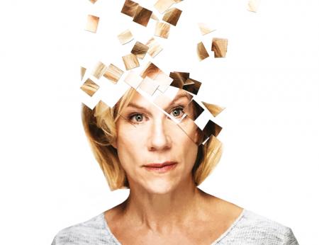Portrait of Juliet Stevenson in front of a white background with the top of her fragmented into square puzzle pieces 