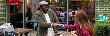 A man holding a woman's hand outside a chip shop.