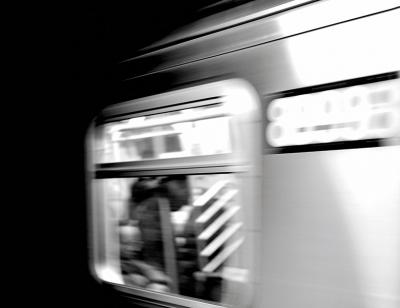 Black and white image of a train window, train has been captured in motion so image is slightly blurred
