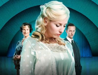 Sinéad Matthews stands in the centre of the image in a white, old-fashioned dress with two people either side of her in the background