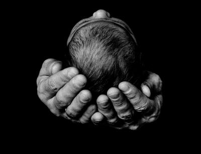 black and white image of two hands holding a babies head